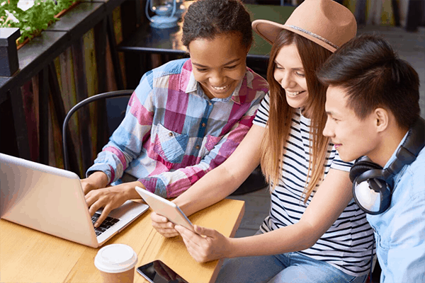 three friends all smiling at a tablet device