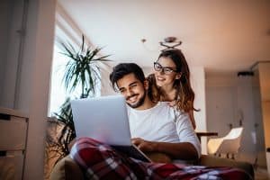 a happy couple looking at a laptop