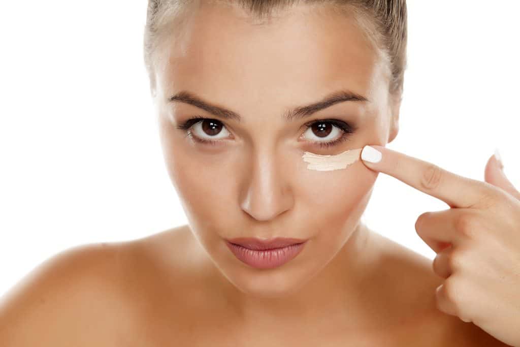 woman applying make up under her eye