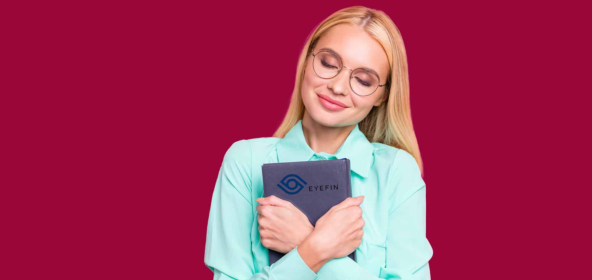 Attractive Blonde lady, smiling while wearing her glasses and holding an Eyefin Contract