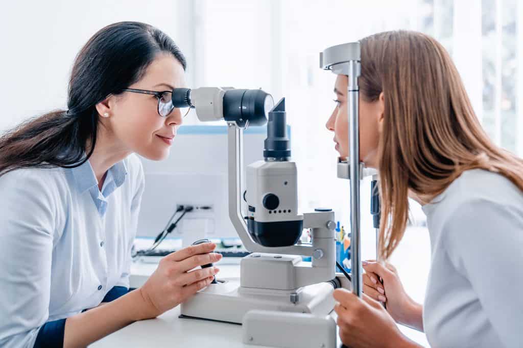 Adult female optometrist checking eye vision